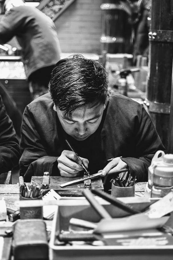 Man making a bracelet in Nanluoguxiang, Beijing